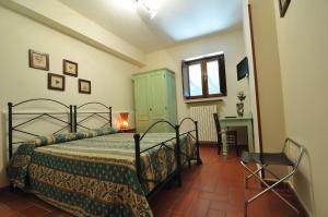 a bedroom with a bed and a desk and a window at Agriturismo La Dimora dei Cavalieri in Vaglio di Basilicata