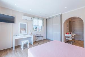 a bedroom with a bed and a desk and a table at Pansion Ermioni in Skala