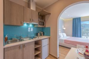 a kitchen with a sink and a bed in a room at Pansion Ermioni in Skala
