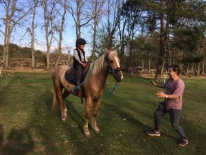 a young girl riding on a horse next to a man at Eco Urbion in Duruelo de la Sierra