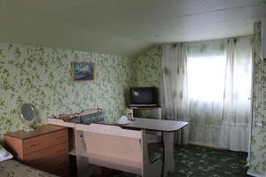 a room with a desk and a tv and a window at Guest House Olga in Kaji-Say