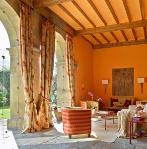 uma sala de estar com cortinas cor de laranja e um sofá em Posada Villa Esperanza em Liérganes