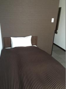 a bedroom with a bed with a striped blanket at Atsugi Hotel Yugiri in Atsugi