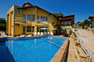 a large swimming pool in front of a house at Iskar Villas in Kranevo
