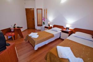 a hotel room with two beds and a television at Iskar Villas in Kranevo +23 photos