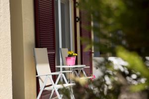 レフカダにあるHouse downtown Lefkadaの椅子2脚、窓際のテーブルに飾られたフラワーポット