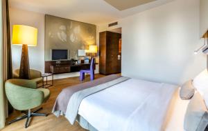 Schlafzimmer mit einem Bett, einem Schreibtisch und einem TV in der Unterkunft Hotel Artemis Amsterdam in Amsterdam + 30 Fotos