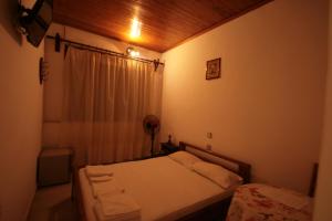 a small bedroom with a bed and a window at Chania Rooms in Chania Town