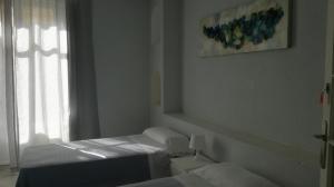 a bedroom with a bed and a window at Pensión Santa Paula in Málaga