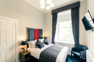 a bedroom with a bed and a window at Argyll Apartments in Glasgow