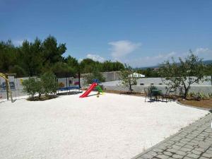 a playground with a red slide in the middle at Apartments T&C in Drage