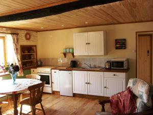 Moutier-Malcard的住宿－Chalet de Rose，厨房配有白色橱柜和一张桌子