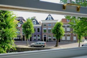 a car parked in front of a row of buildings at Huisje aan de gracht in Franeker