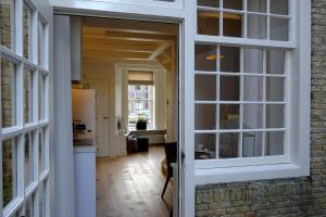 an open door to a kitchen and a living room at Huisje aan de gracht in Franeker