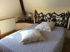 een slaapkamer met een groot bed met twee kussens bij Demeure d'hôtes Les Irisynes in Viviers-du-Lac