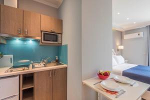a small kitchen with a sink and a bed at Pansion Ermioni in Skala