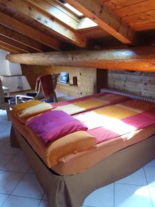 a large bed in a room with a wooden ceiling at Casa Di Lena in Gravedona