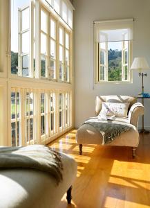 a living room with a couch and large windows at Posada Villa Esperanza in Liérganes