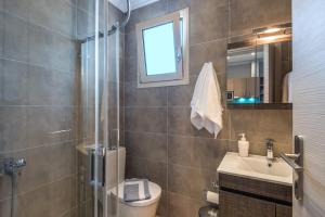 a bathroom with a toilet and a sink and a mirror at Pansion Ermioni in Skala