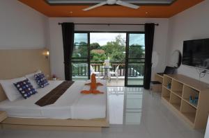 a bedroom with a large bed and a sliding glass door at Duangjai Residence - SHA Extra Plus in Rawai Beach