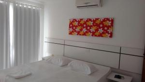 Un dormitorio con una cama y un cuadro en la pared. en Apartment Mont Moria, en Porto Seguro