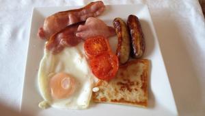 un plato de desayuno con salchichas y tostadas en Inishowen Lodge B&B, en Moville