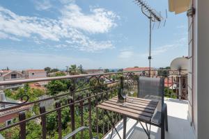 a balcony with a wooden bench on a railing at Pansion Ermioni in Skala