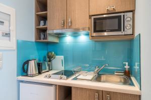 a kitchen with a sink and a microwave at Pansion Ermioni in Skala