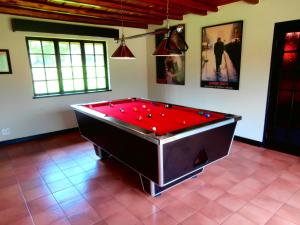 una sala biliardo con tavolo rosso di African Footprints Lodge a Midrand