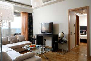 a living room with a couch and a tv at Elite City Resort in Kalamata