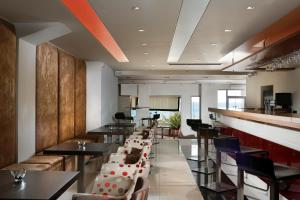 a restaurant with tables and chairs and a bar at Elite City Resort in Kalamata