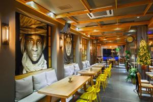 a restaurant with wooden tables and yellow chairs at Elite City Resort in Kalamata