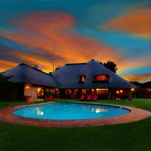 a house with a swimming pool in front of it at African Footprints Lodge in Midrand