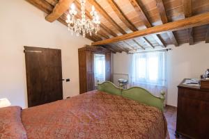 a bedroom with a bed and a chandelier at Casa Vacanza Il Tiglio in Sassoferrato