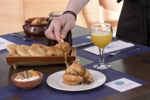 a person eating food on a table with a glass of wine at Elite City Resort in Kalamata