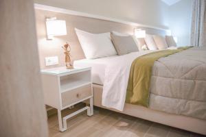 um pequeno quarto com uma cama e uma mesa de cabeceira em Hotel Vizantio em Paralia Katerinis