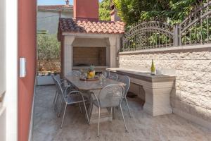 einen Tisch und Stühle auf einer Terrasse mit Kamin in der Unterkunft Vila Snjezana in Trogir