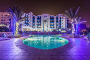 a resort with a swimming pool at night at Oasis Hotel & Spa in Agadir