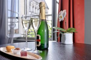 uma garrafa de champanhe e dois copos numa mesa em Hôtel Ligaro em Jarnac