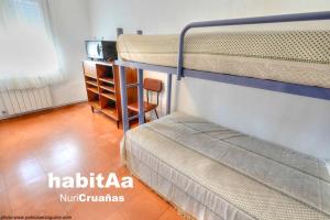 two bunk beds in a room with a desk at Quintas de Sant Pol, a 50 metros de la playa de Sant Pol E29049 in Sant Feliu de Guíxols