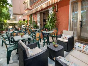 un patio esterno con tavoli, sedie, tavoli e sedie di Hotel Miramare a Cattolica