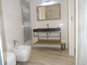a bathroom with a sink and a toilet and a mirror at Suites Margot in Santa Margherita Ligure