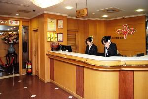 two women sitting at a bar talking on a cell phone at Ying Zhen Hotel in Taoyuan