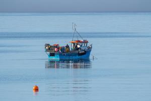 a blue boat in the middle of the water at Port Charlotte Hotel in Port Charlotte