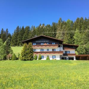 ein großes Gebäude in der Mitte eines Feldes in der Unterkunft Pension Margret in Leutasch