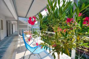 een balkon met tafels en stoelen en roze bloemen bij Villa Oliver 3 Siófok in Siófok