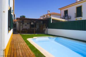 a swimming pool in a yard next to a house at Arrabida´s Sweet Home in Azeitao