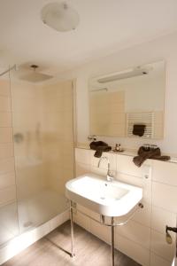 a bathroom with a sink and a shower at Dooscht Gästehaus Reichshof in Kröv