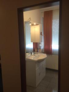 ein Bad mit einem Waschbecken und einem Spiegel in der Unterkunft WH Monteurhotel Papenburg Nord in Papenburg