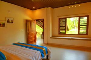 1 dormitorio con cama y ventana en Casa Marari, en Mararikulam